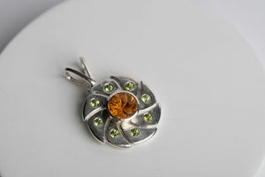 Sterling silver 10mm round vortex cut citrine bezel set pendant flanked with 8 green peridot by Brian Bibeau Designs.