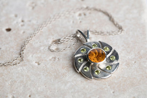 Sterling silver 10mm round vortex cut citrine bezel set pendant flanked with 8 green peridot by Brian Bibeau Designs.