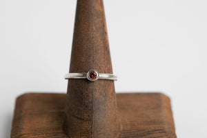 Sterling silver 3mm round cabochon garnet bezel set ring by Brian Bibeau Designs.